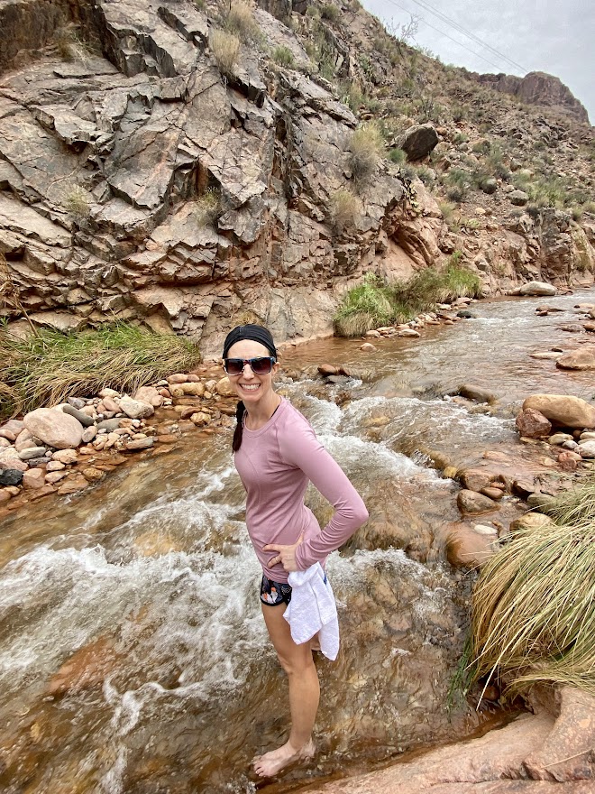 girl standing in river at the bottom of the grand canyon