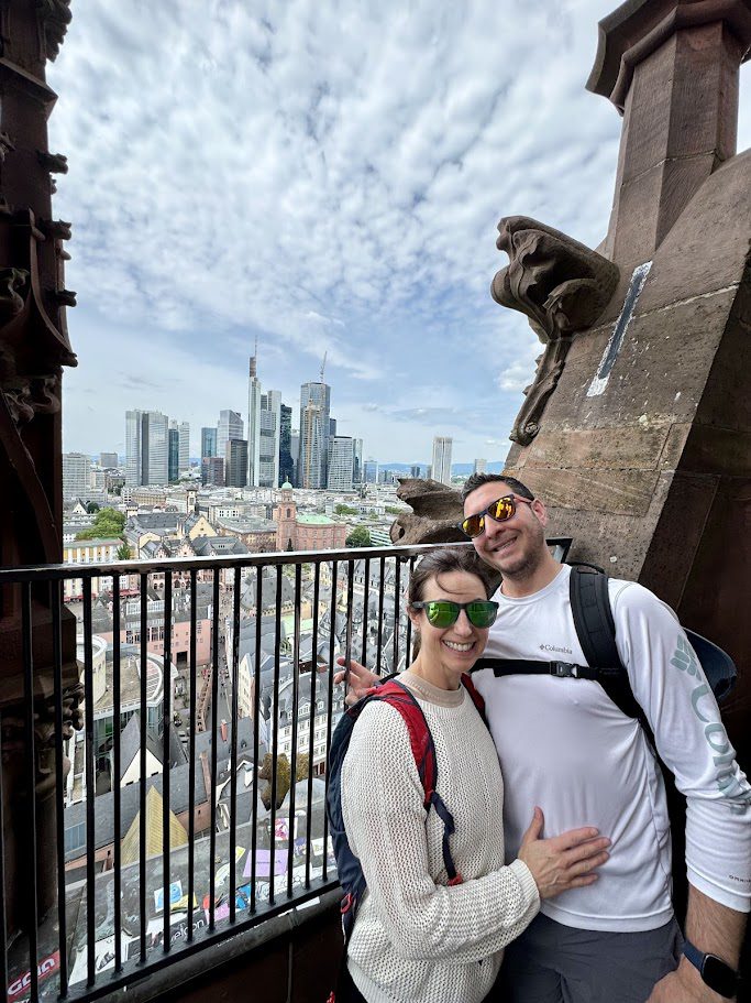 couple at the top of the frankfurt cathedral overlooking city skyline germany